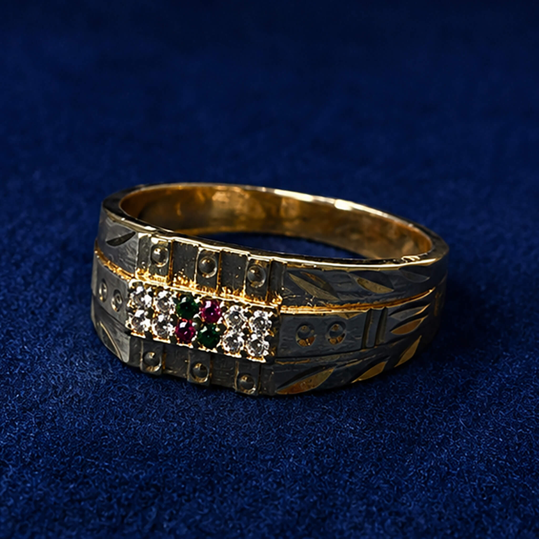 Dual-tone gold and silver ring featuring crystal stones with ruby and emerald accents on a royal blue velvet background.