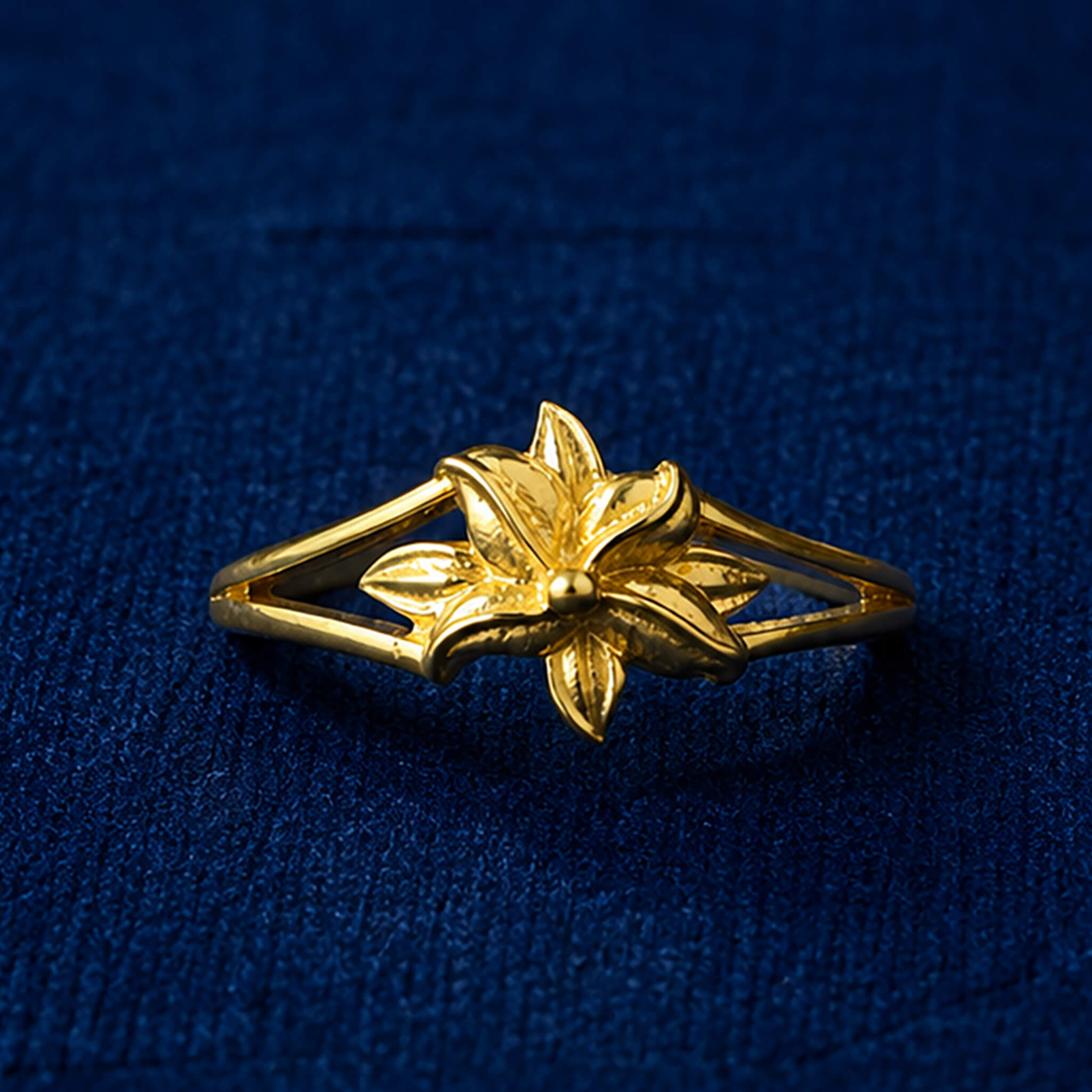 Gold-tone butterfly ring with detailed wings displayed on a royal blue velvet background.