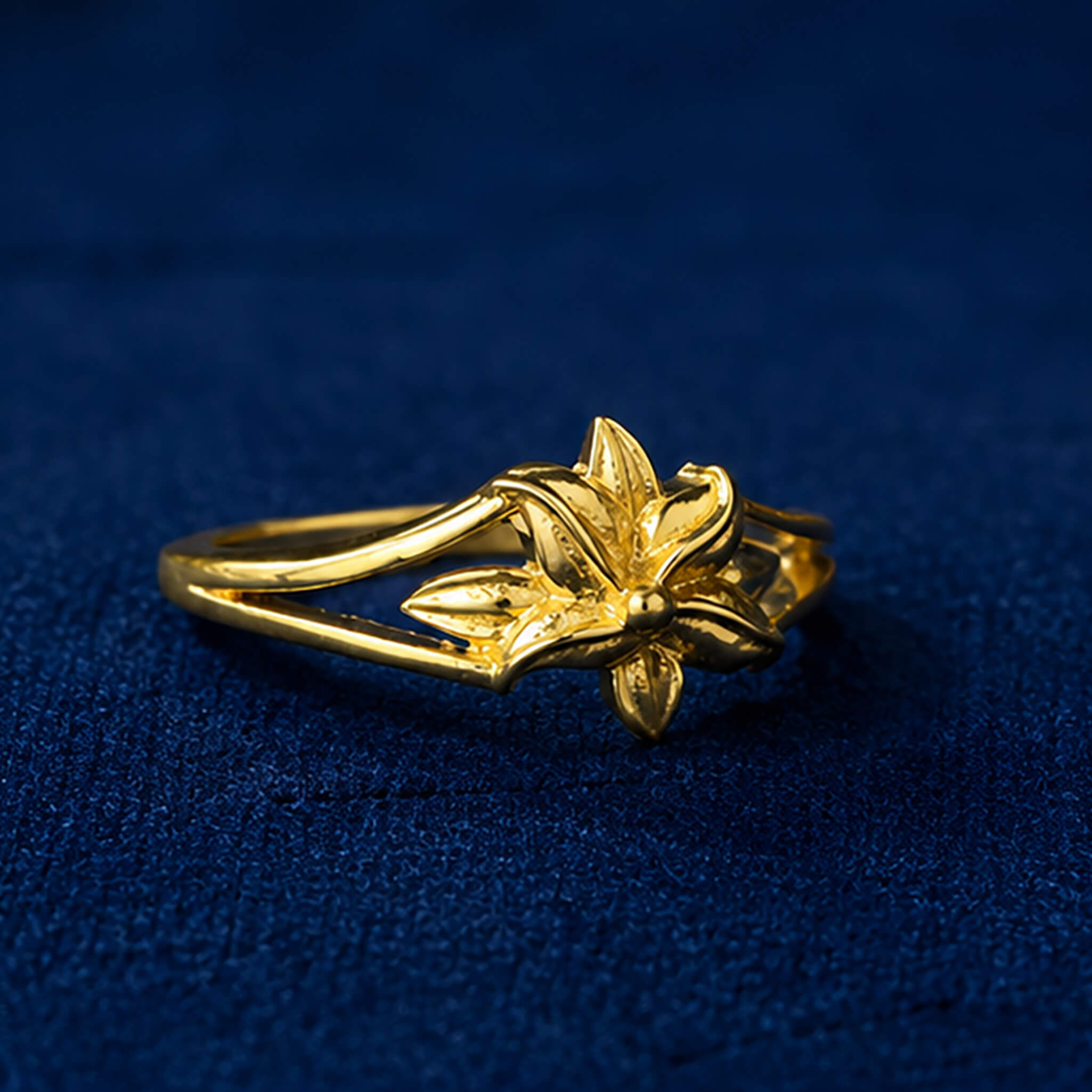 Gold-tone butterfly ring with detailed wings displayed on a royal blue velvet background.