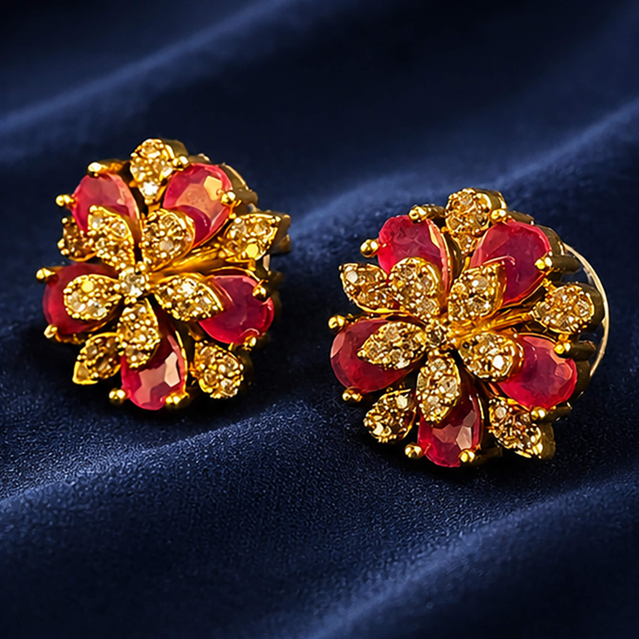 Gold-tone floral necklace set with red enamel flowers and matching ear tops displayed on a royal blue velvet jewelry stand.