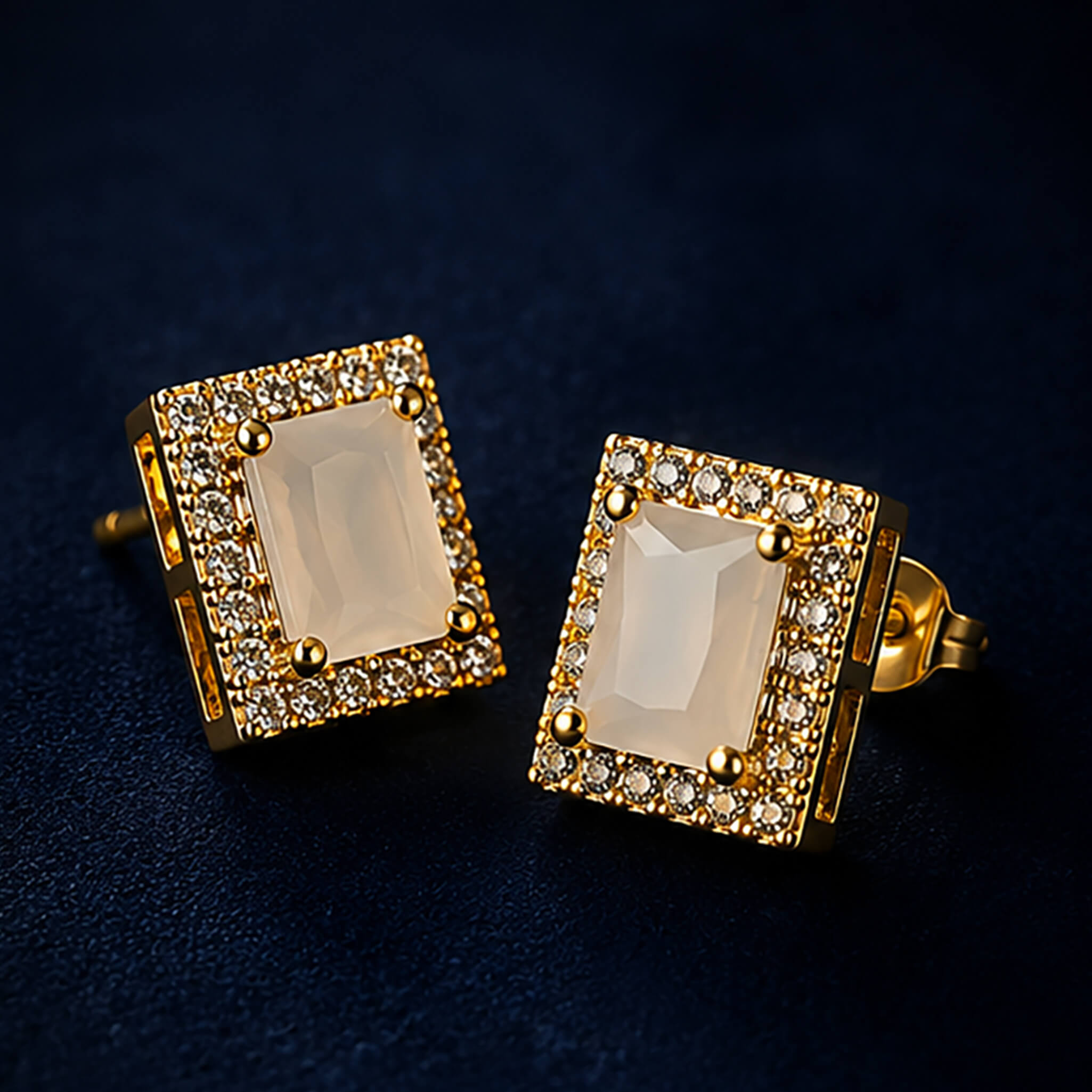 Gold-tone pendant necklace and matching earrings with ivory-white rectangular stones and crystal accents on a dark blue background.