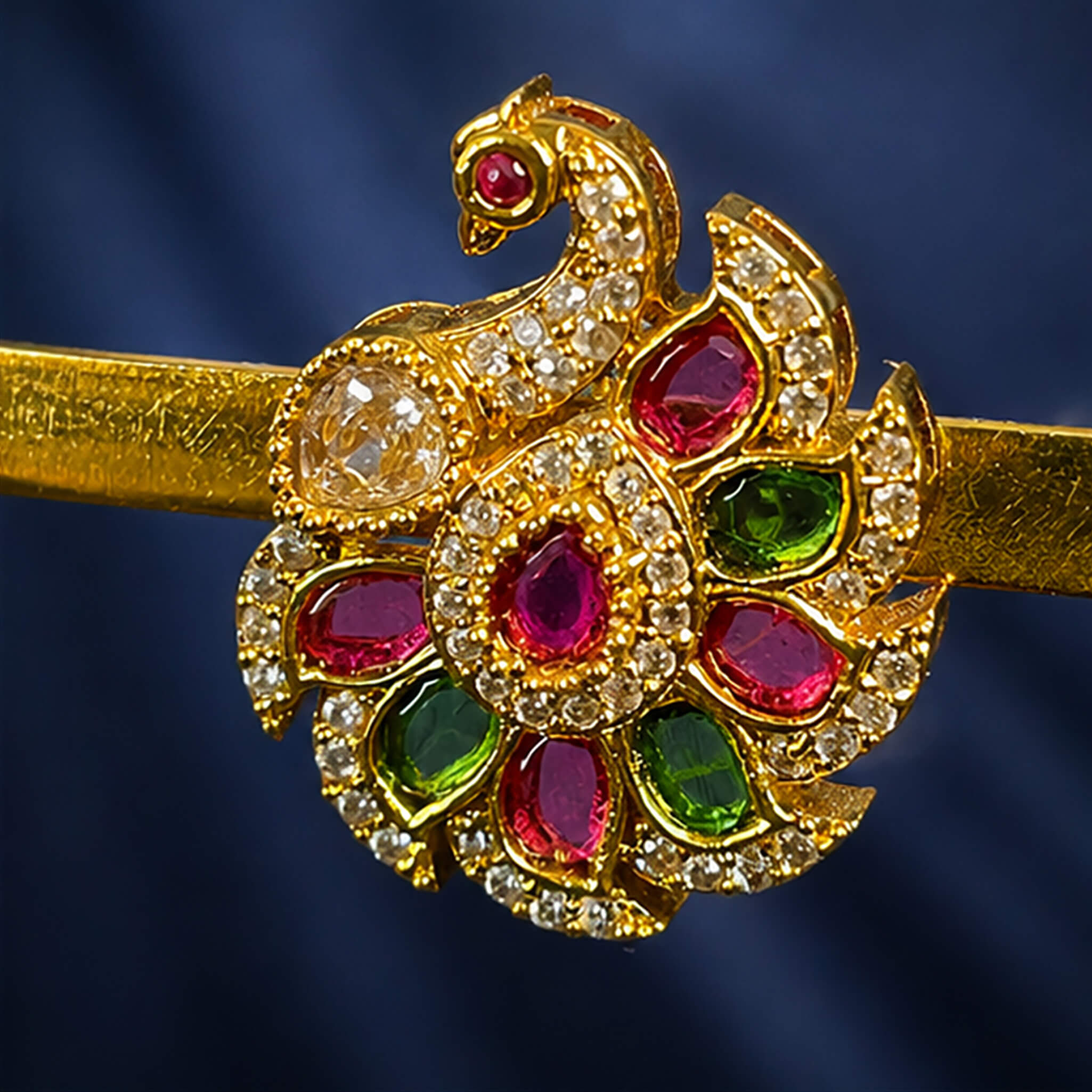 Gold-tone floral ear tops featuring pink ruby stones, green emerald stones, and sparkling crystal accents on a royal blue background.
