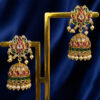 Traditional gold-tone jhumka ear tops with ruby-red stones, emerald-green stones, crystal accents, and pearl danglers on a royal blue background.